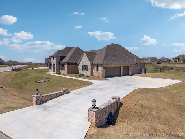 french provincial home with a front yard, fence, brick siding, a garage, and concrete driveway