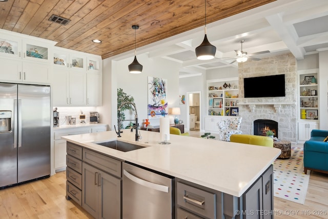 kitchen with gray cabinets, open floor plan, light wood-style floors, stainless steel appliances, and wood ceiling