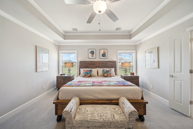 carpeted bedroom featuring crown molding, visible vents, baseboards, and a raised ceiling