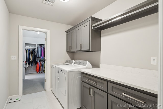 laundry area featuring independent washer and dryer, visible vents, marble finish floor, baseboards, and cabinet space
