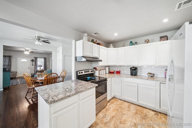 kitchen featuring stainless steel range with electric cooktop, freestanding refrigerator, tasteful backsplash, visible vents, and under cabinet range hood