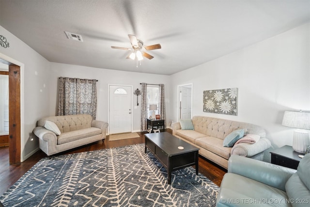 living area featuring visible vents, baseboards, a ceiling fan, and wood finished floors