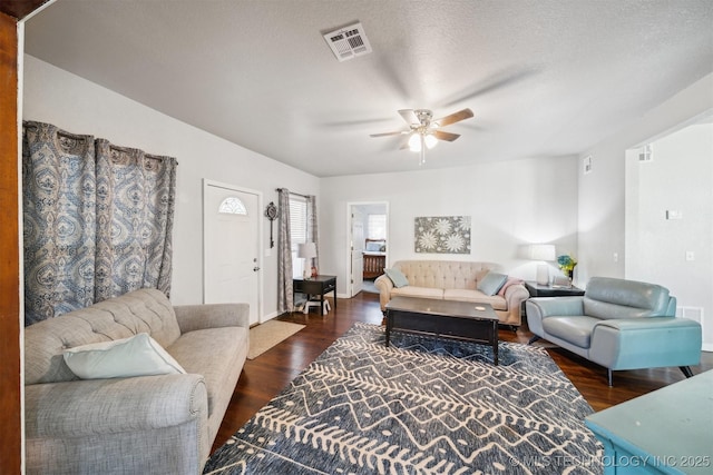 living room with visible vents, baseboards, ceiling fan, a textured ceiling, and wood finished floors