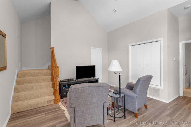 2667 Duguid Ln, Kingston, OK 73439 - living area with high vaulted ceiling, wood finished floors, stairway, and baseboards