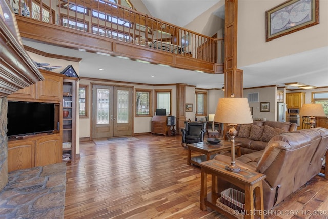 2667 Duguid Ln, Kingston, OK 73439 - living room featuring high vaulted ceiling, plenty of natural light, light wood-style flooring, ornamental molding, and french doors