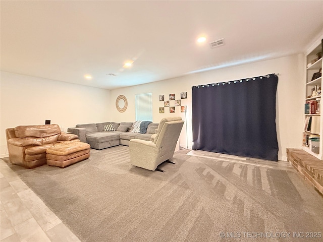 living room with recessed lighting, carpet flooring, and visible vents