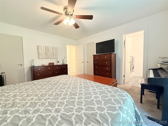 bedroom featuring ensuite bath, a ceiling fan, and carpet floors