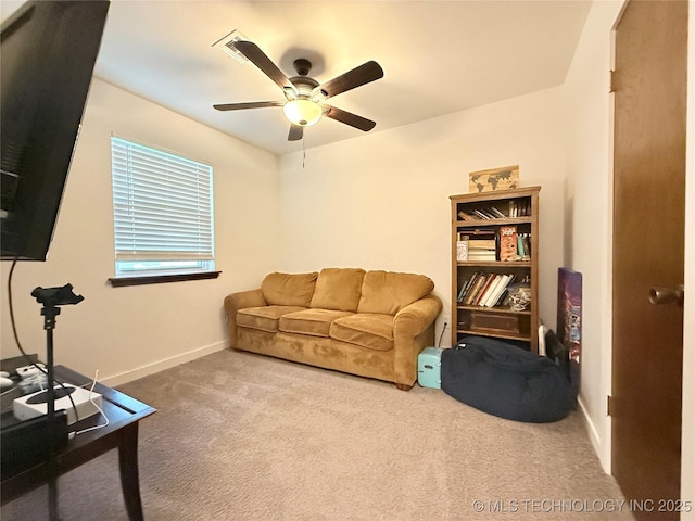 living area featuring carpet floors, baseboards, and a ceiling fan