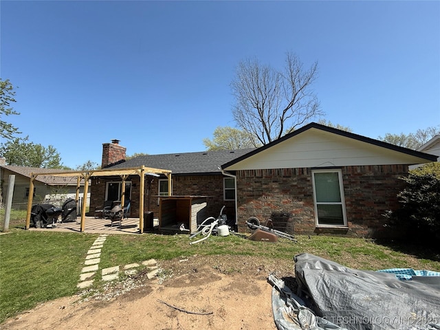 rear view of house with a pergola, a patio area, a yard, a chimney, and brick siding