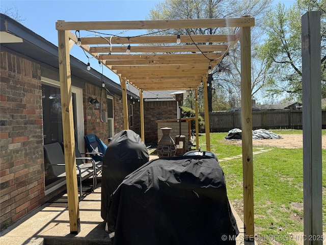 view of patio featuring fence, area for grilling, and a pergola