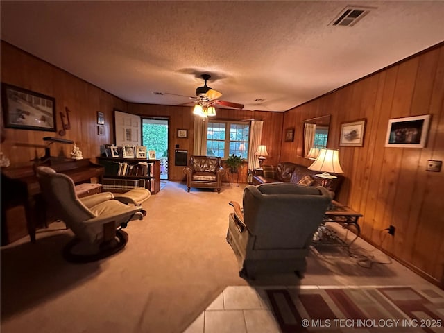 10348 W 805th Rd, Fort Gibson, OK 74434 - living room featuring a ceiling fan, a textured ceiling, visible vents, wooden walls, and light carpet
