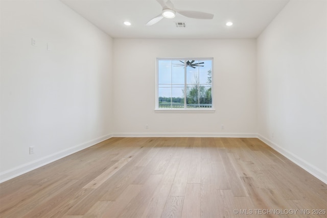 spare room with baseboards, visible vents, light wood-type flooring, and a ceiling fan