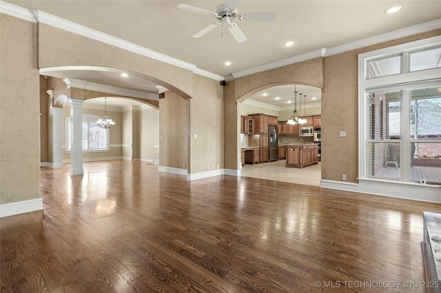 7505 S 4th St, Broken Arrow, OK 74011 - unfurnished living room with a chandelier, arched walkways, plenty of natural light, crown molding, and recessed lighting