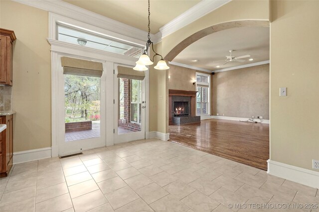 7505 S 4th St, Broken Arrow, OK 74011 - unfurnished living room with ceiling fan, ornamental molding, a premium fireplace, arched walkways, and baseboards
