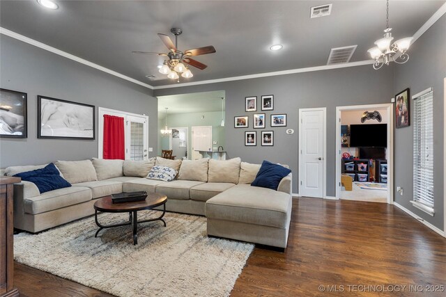 living area featuring ornamental molding, visible vents, dark wood finished floors, and ceiling fan with notable chandelier