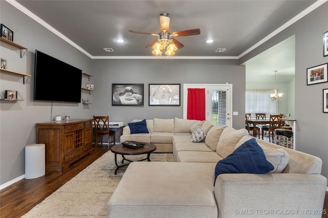 living room featuring dark wood-type flooring, visible vents, a ceiling fan, and crown molding