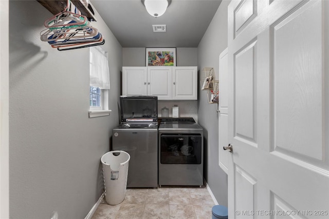clothes washing area featuring separate washer and dryer, baseboards, light tile patterned floors, visible vents, and cabinet space