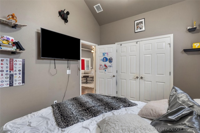 bedroom featuring visible vents, a closet, and lofted ceiling