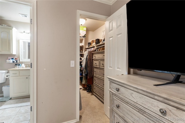 spacious closet with light colored carpet and visible vents