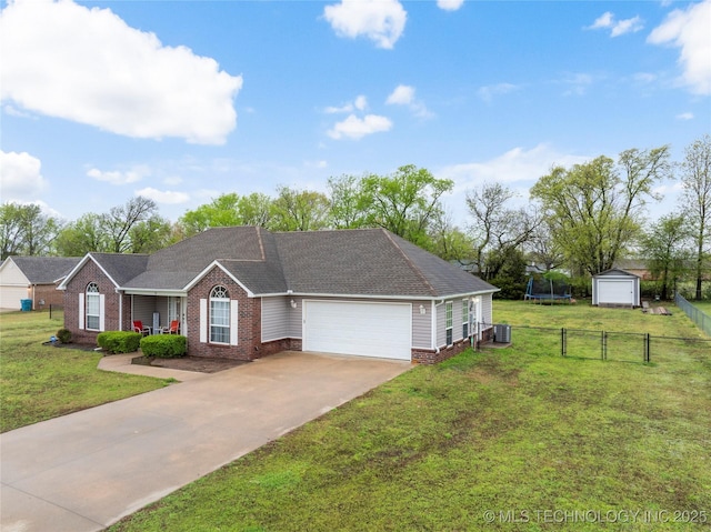 single story home featuring a trampoline, driveway, an attached garage, and a front lawn