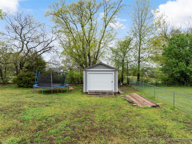 view of yard with a trampoline, a shed, a fenced backyard, and an outdoor structure