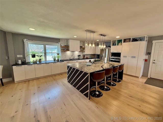 kitchen featuring stainless steel fridge with ice dispenser, tasteful backsplash, light wood-style floors, and open shelves
