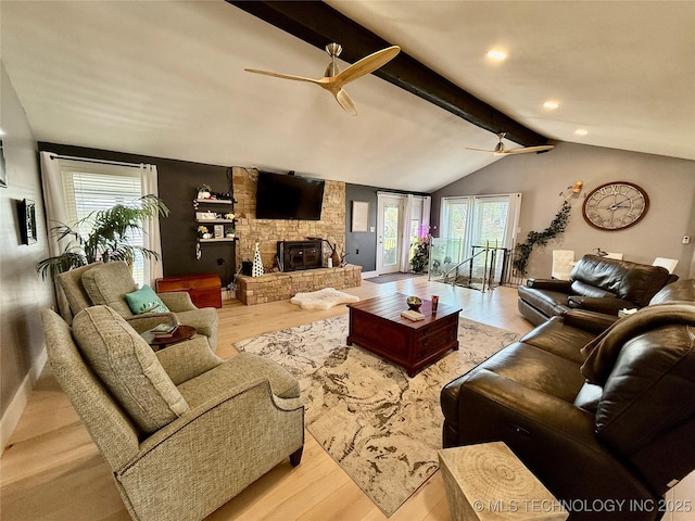 living area featuring a fireplace, ceiling fan, wood finished floors, and lofted ceiling with beams