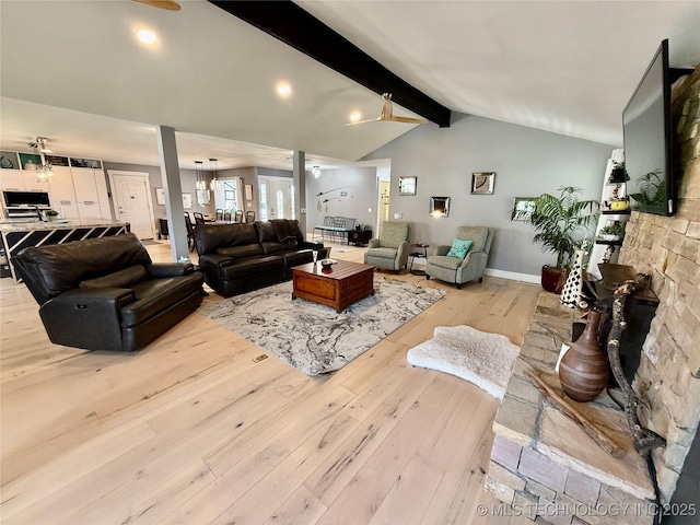 living room with light wood finished floors, lofted ceiling with beams, and baseboards