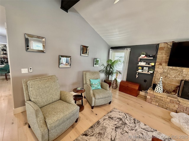 sitting room with beam ceiling, high vaulted ceiling, and wood finished floors