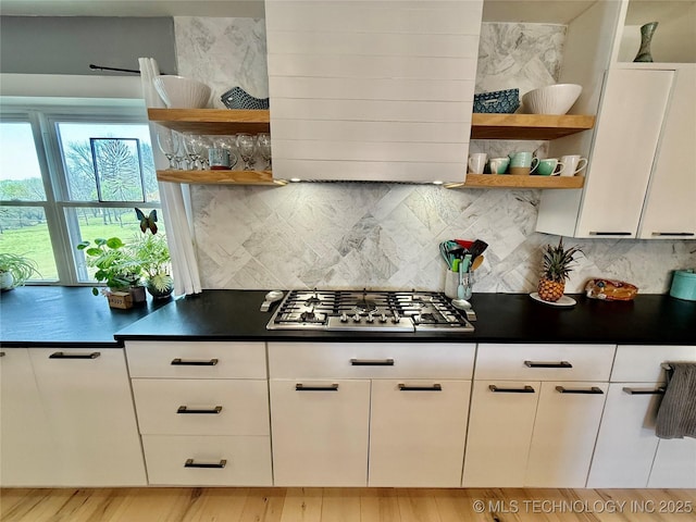 kitchen featuring stainless steel gas cooktop, dark countertops, and open shelves