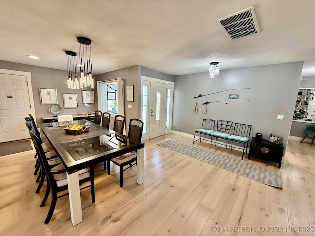 dining area featuring light wood-type flooring, baseboards, and visible vents