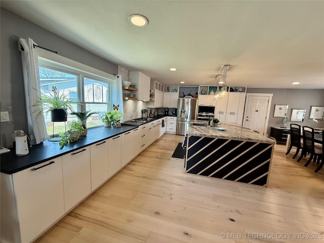 kitchen featuring stainless steel fridge with ice dispenser, light wood-style flooring, backsplash, open shelves, and gas cooktop