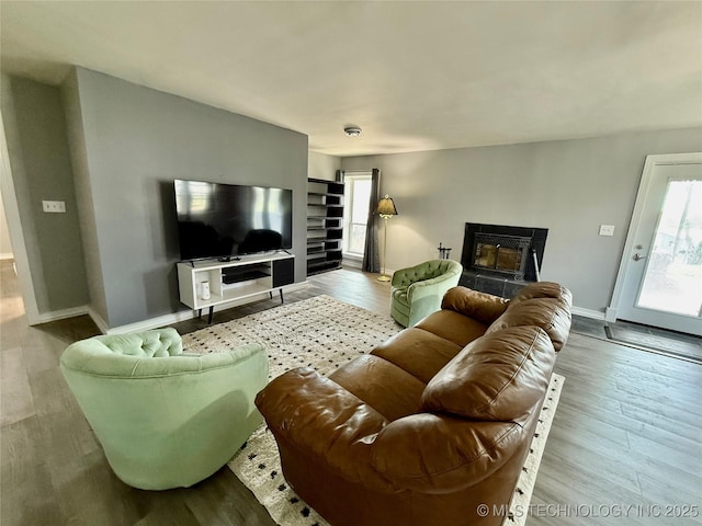 living room with a wealth of natural light, baseboards, and wood finished floors