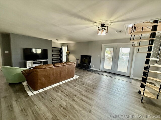 living area featuring baseboards, wood finished floors, and stairs