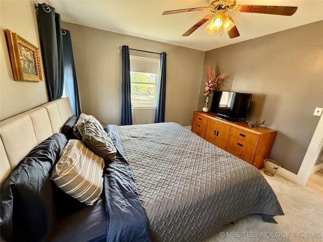 carpeted bedroom with baseboards and a ceiling fan