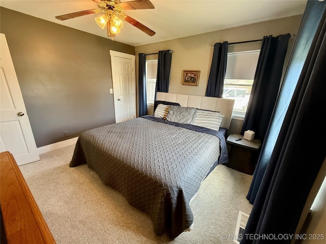 carpeted bedroom with baseboards and a ceiling fan