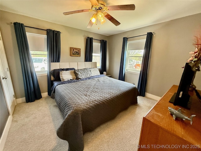 bedroom featuring baseboards, a ceiling fan, and light carpet