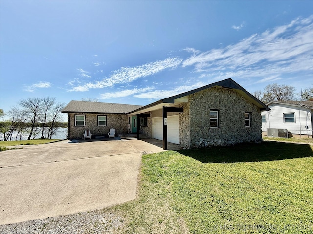 view of front of house with cooling unit, stone siding, a front lawn, an attached garage, and concrete driveway