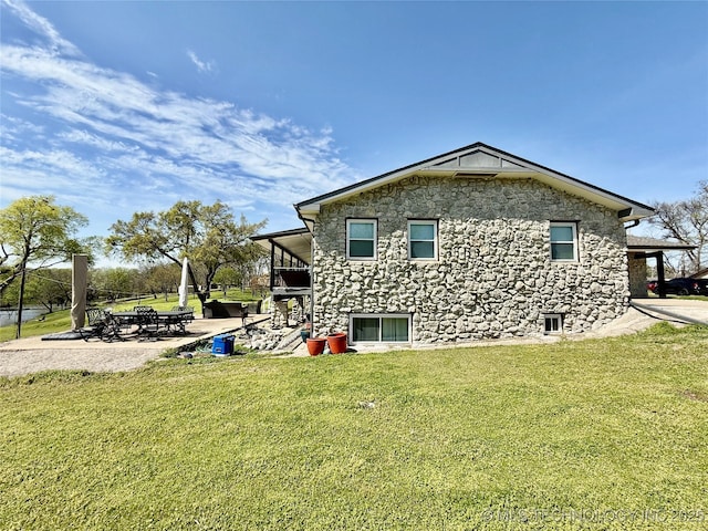 exterior space featuring a yard, a patio area, and stone siding
