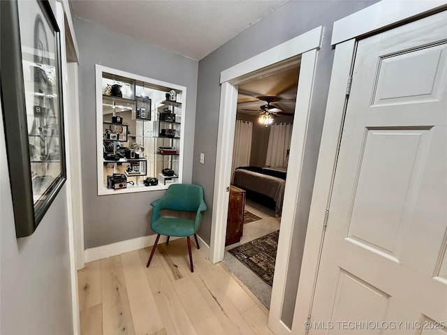 hallway with light wood-style floors and baseboards
