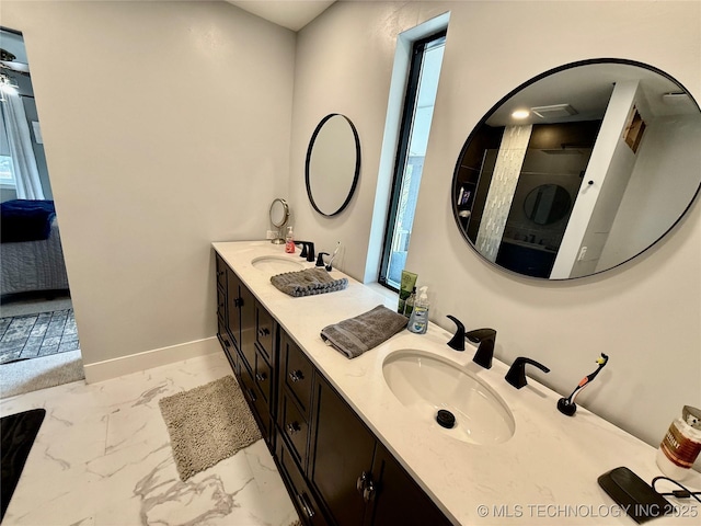 bathroom with a sink, baseboards, double vanity, and marble finish floor