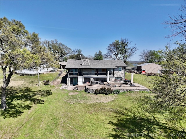 rear view of property with a yard, a patio, and a sunroom