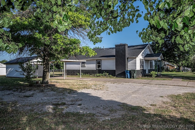 804 S Sooner Rd, Midwest City, OK 73110 - view of front of house featuring a carport, a chimney, driveway, and a shingled roof