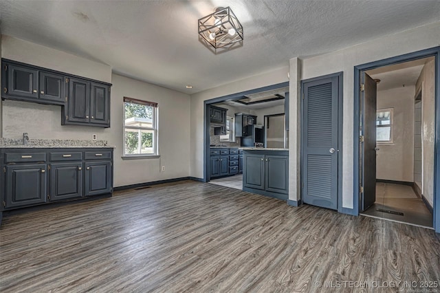 804 S Sooner Rd, Midwest City, OK 73110 - kitchen with a textured ceiling, wood finished floors, light countertops, baseboards, and fridge