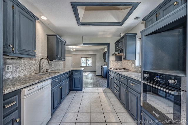804 S Sooner Rd, Midwest City, OK 73110 - kitchen with light tile patterned floors, oven, white dishwasher, a sink, and backsplash