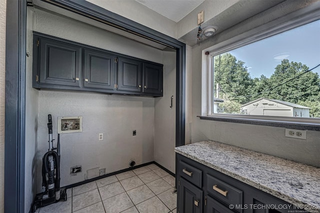804 S Sooner Rd, Midwest City, OK 73110 - laundry area with light tile patterned floors, baseboards, washer hookup, cabinet space, and electric dryer hookup