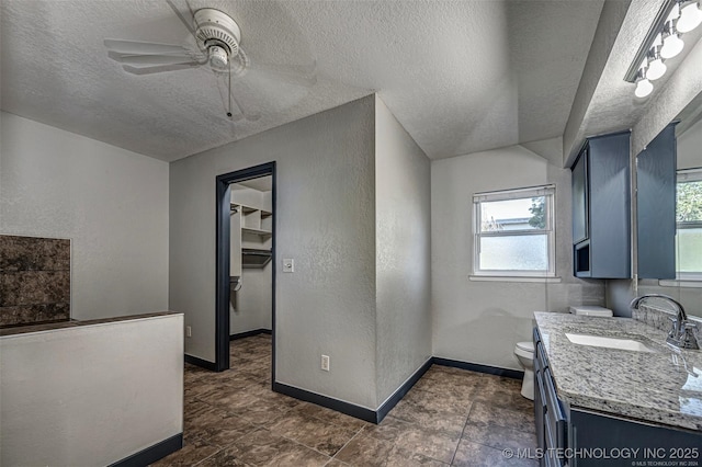 804 S Sooner Rd, Midwest City, OK 73110 - kitchen featuring a textured wall, blue cabinetry, a sink, and a ceiling fan