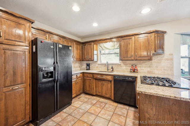 1604 S Chestnut Ave, Broken Arrow, OK 74012 - kitchen featuring black appliances, brown cabinets, decorative backsplash, recessed lighting, and light stone counters