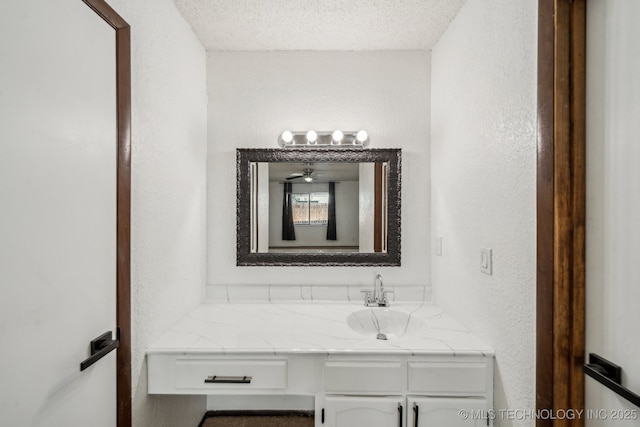 11024 E 15th St, Tulsa, OK 74128 - bathroom with vanity, a textured wall, a textured ceiling, and a ceiling fan