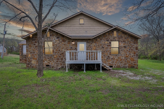 15338 S Brewster Rd, Mounds, OK 74047 - back of house at dusk with a lawn, crawl space, and stone siding